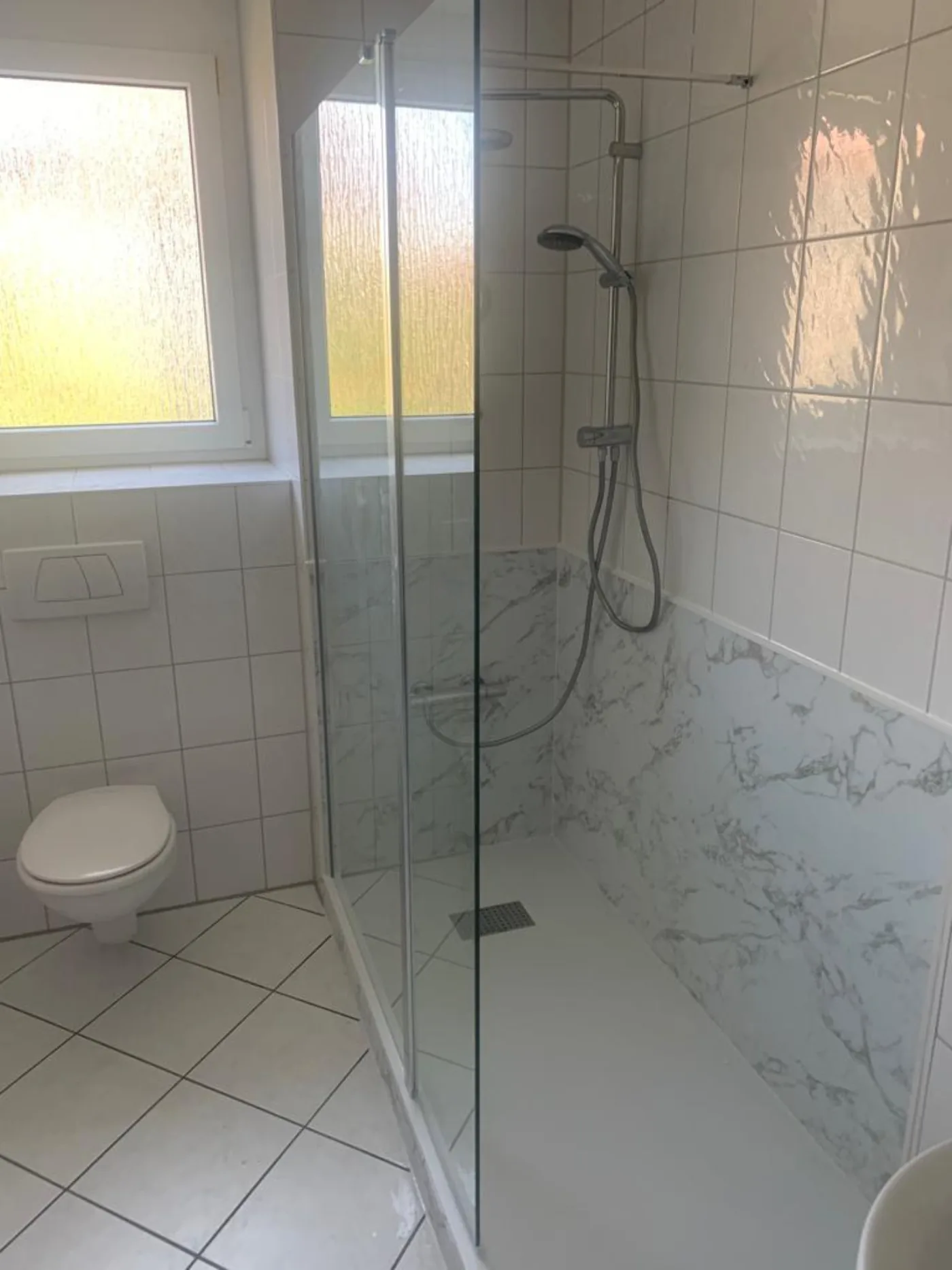 Fertige Dusche mit hellen Wandpaneelen in Marmoroptik