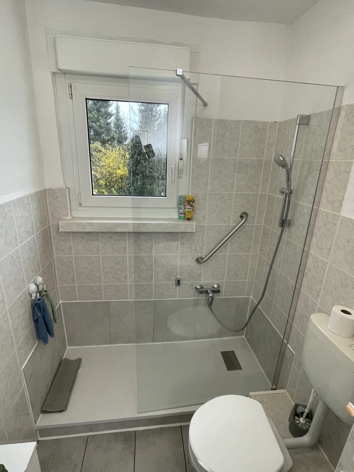 Fertige Dusche mit Haltegriff, Glasabtrennung und bodennaher Duschfläche